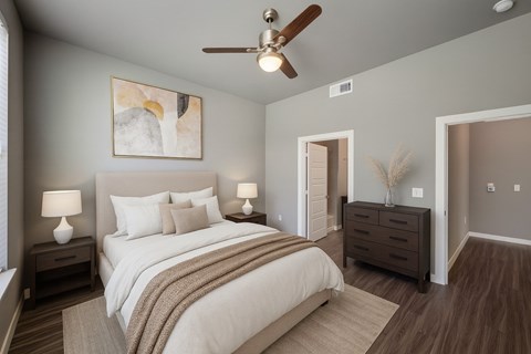 A bedroom with a large bed and a ceiling fan.