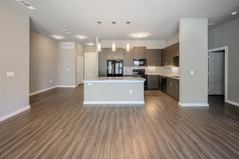 A spacious kitchen with wooden flooring and modern appliances.