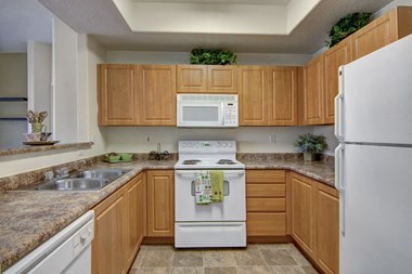 a kitchen with wooden cabinets and white appliances