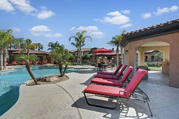 a pool with red chaise lounges and palm trees - Photo Gallery 15