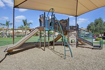 a playground with two slides and a climbing structure