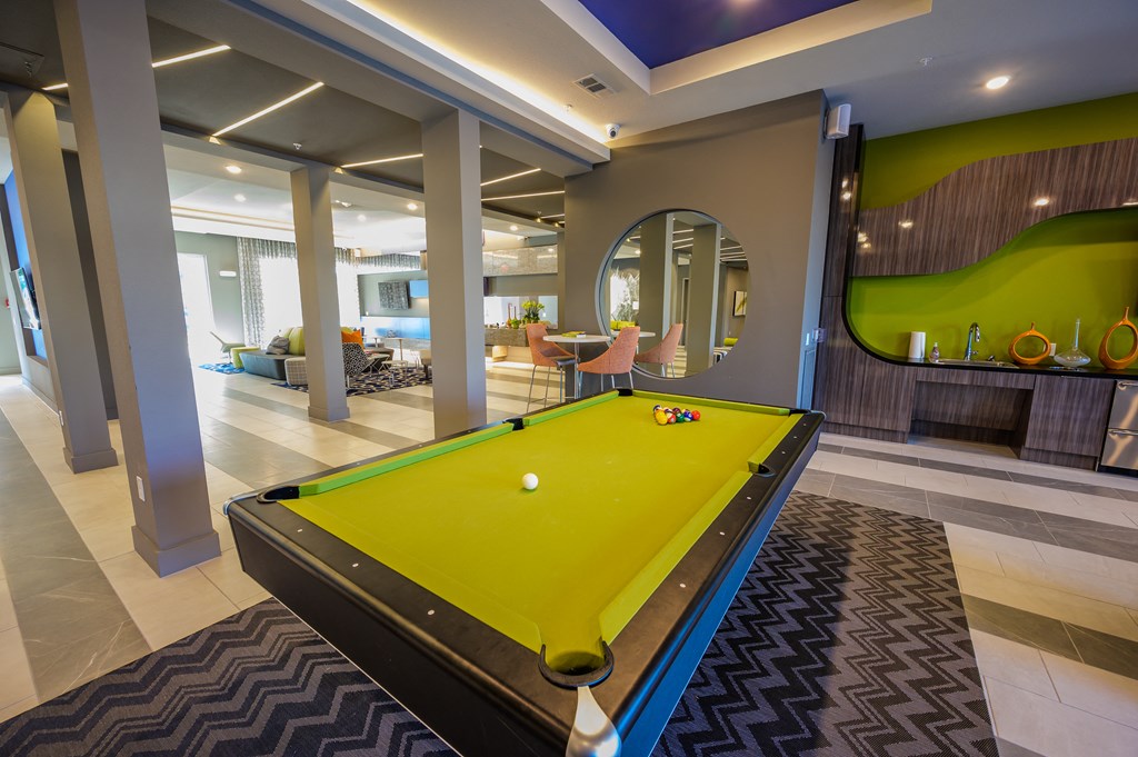a pool table in a clubhouse with a yellow ball on it
