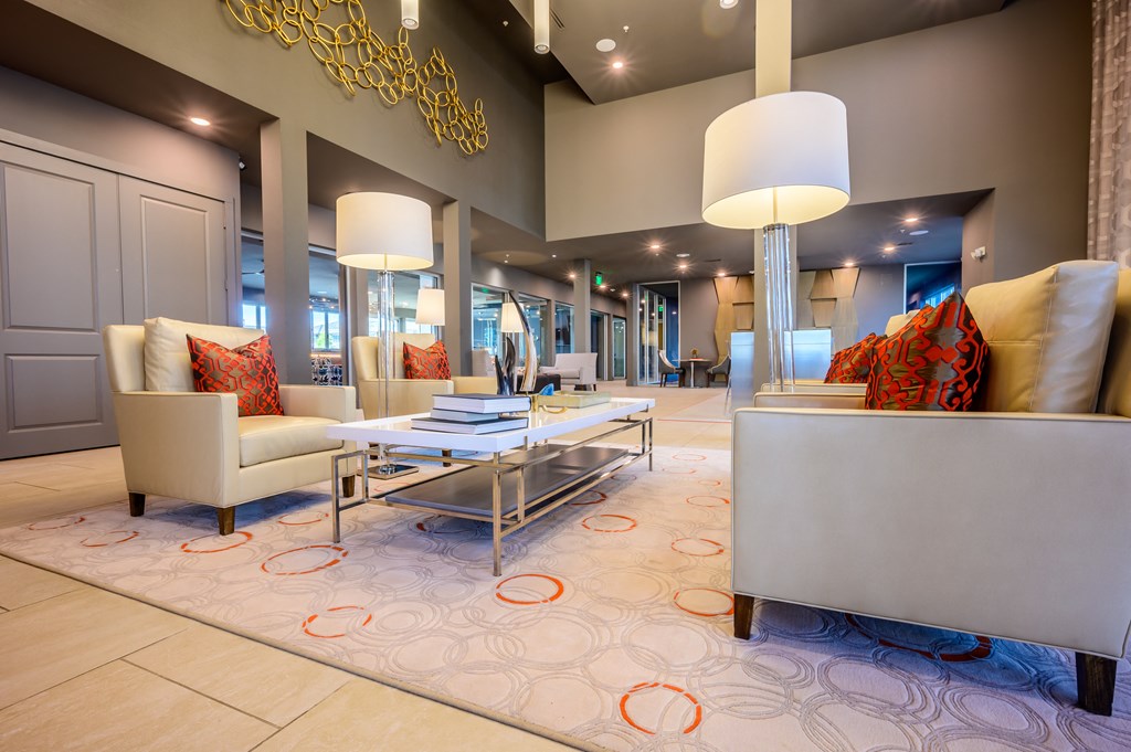 a living room with couches chairs and lamps and a rug