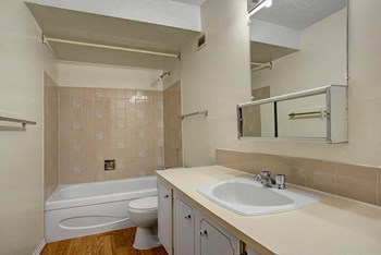 A bathroom with shower, tub, and a mirror above the sink Edgemont Heights Apartment Homes Bathroom - Photo Gallery 3