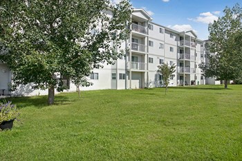 The exterior of the property surrounded by grass and trees Edgewood Estates Exterior - Photo Gallery 6