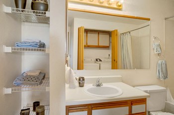 A bathroom with linen closet, shower and bathtub, and a full size washer and dryer Glennbrook Bathroom - Photo Gallery 4