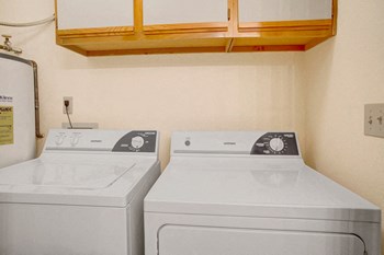 A full size washer and dryer with cabinets above for additional storage Glennbrook Laundry - Photo Gallery 6