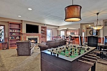 a game room with a foosball table and a fireplace