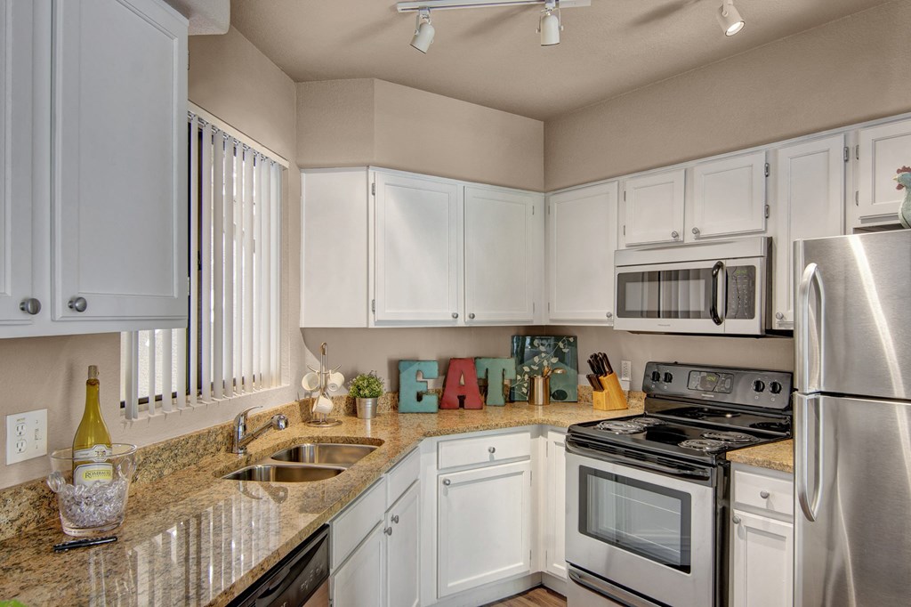 a kitchen with white cabinets and a granite counter top