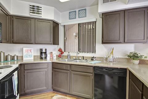 a kitchen with gray cabinets and a black dishwasher
