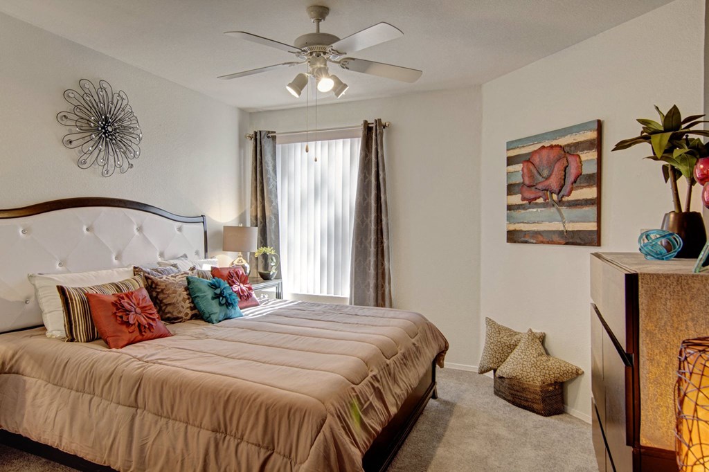 a bedroom with a large bed and a ceiling fan
