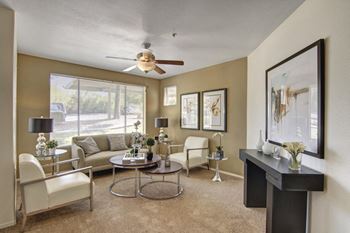 a living room with a large window and a ceiling fan