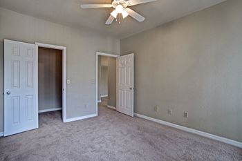 a bedroom with a ceiling fan and two doors