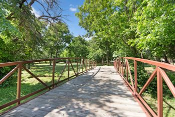 a bridge over a grassy area with trees