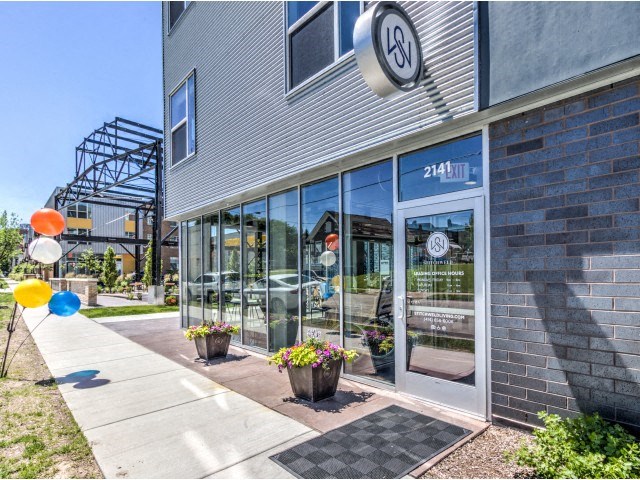 Stitchweld Apartments features a modern building exterior with large glass windows that reflect another building.