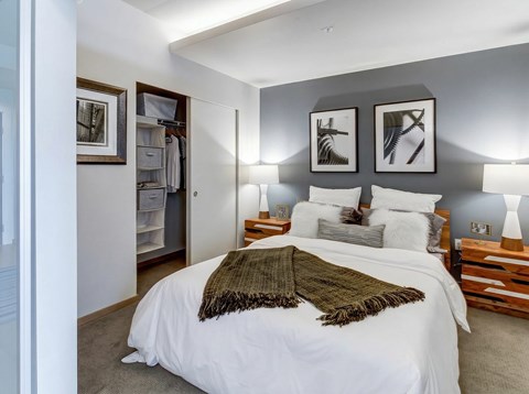 A bedroom with a large bed and a green throw blanket.