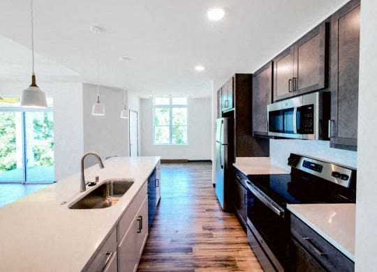 a large kitchen with black appliances and white counter tops