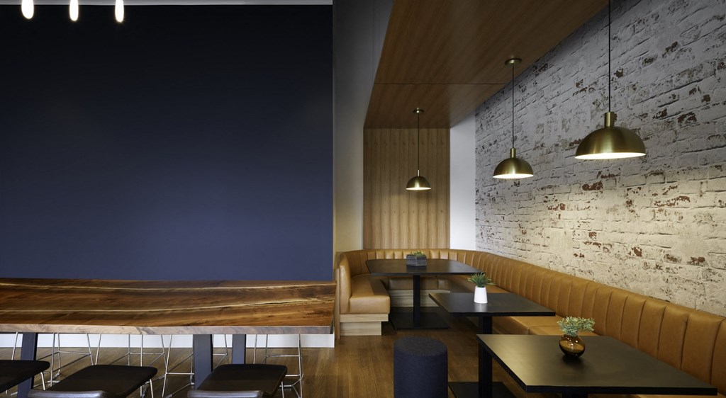 a dining room with tables and chairs and a brick wall