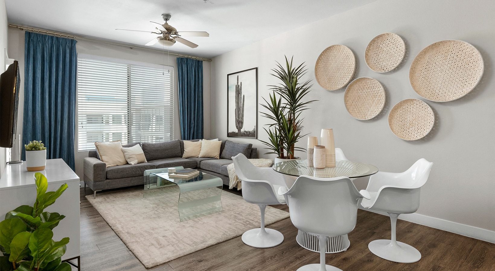 a living room with a couch and a table and a ceiling fan