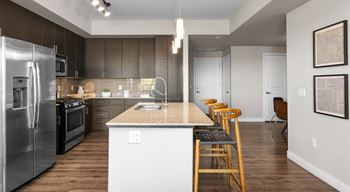 a kitchen with a island and a stainless steel refrigerator