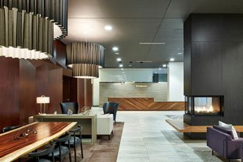 the lobby of a hotel with a fireplace and tables and chairs