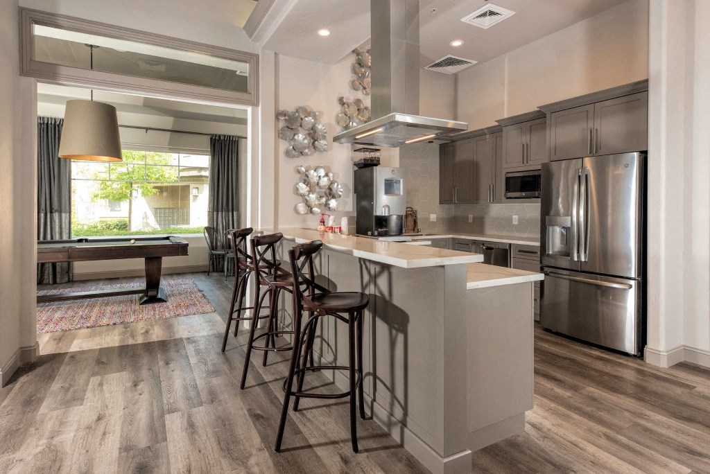 a kitchen with a large island with bar stools