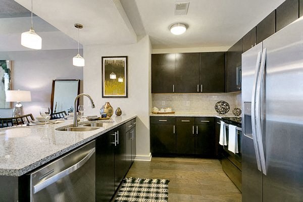 a kitchen with a stainless steel refrigerator and a sink
