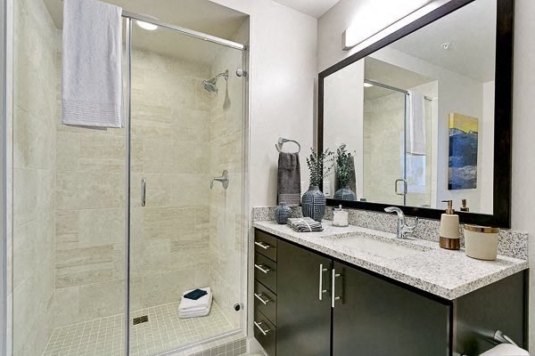 a bathroom with a shower and a sink and a mirror