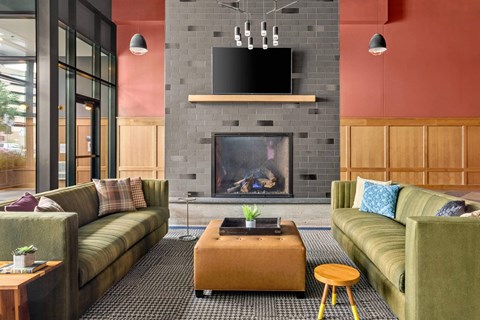 A modern living room with a fireplace and a television above it.
