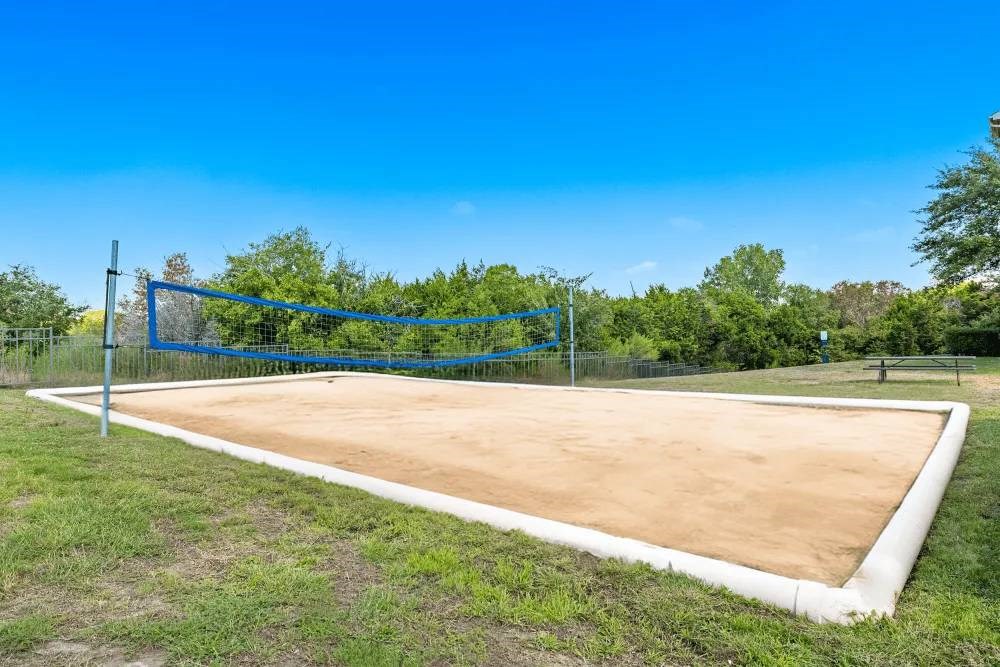 A tennis court with a blue net and white boundary lines.