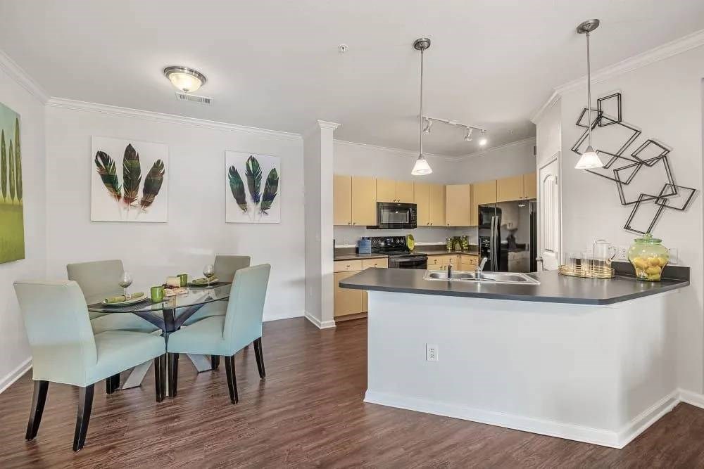 A kitchen with a dining table and chairs.