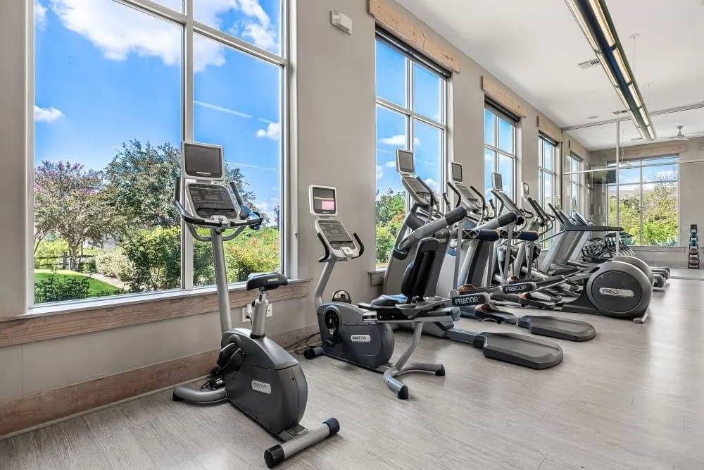 A gym with treadmills, elliptical machines, and stationary bikes.