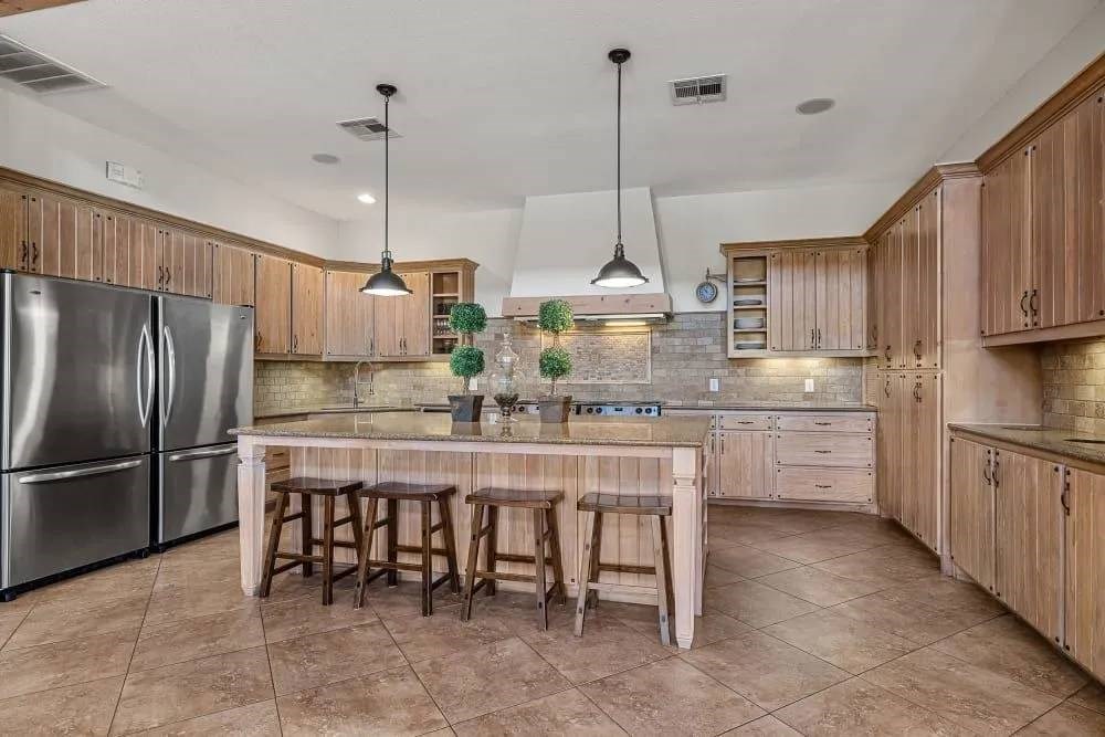 A kitchen with wooden cabinets and a tile floor.