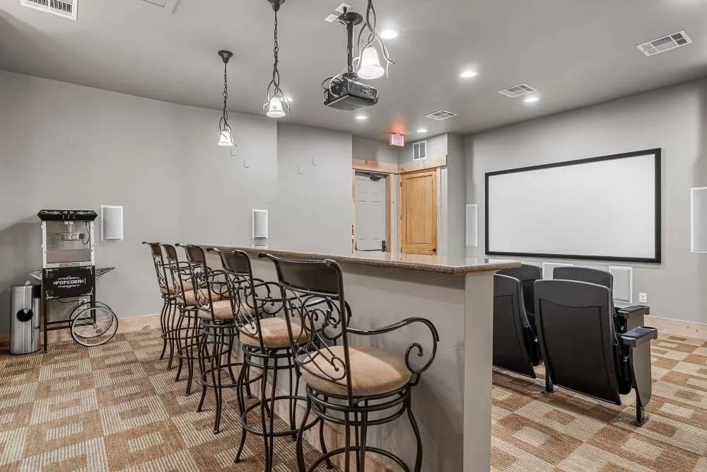 A room with a bar and chairs.
