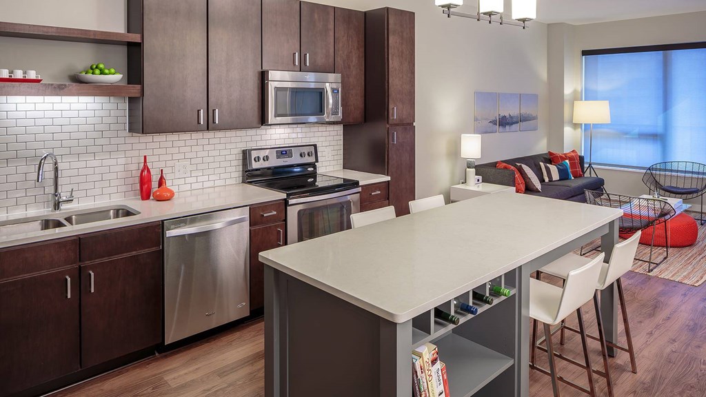 A modern kitchen with a large island and stainless steel appliances.