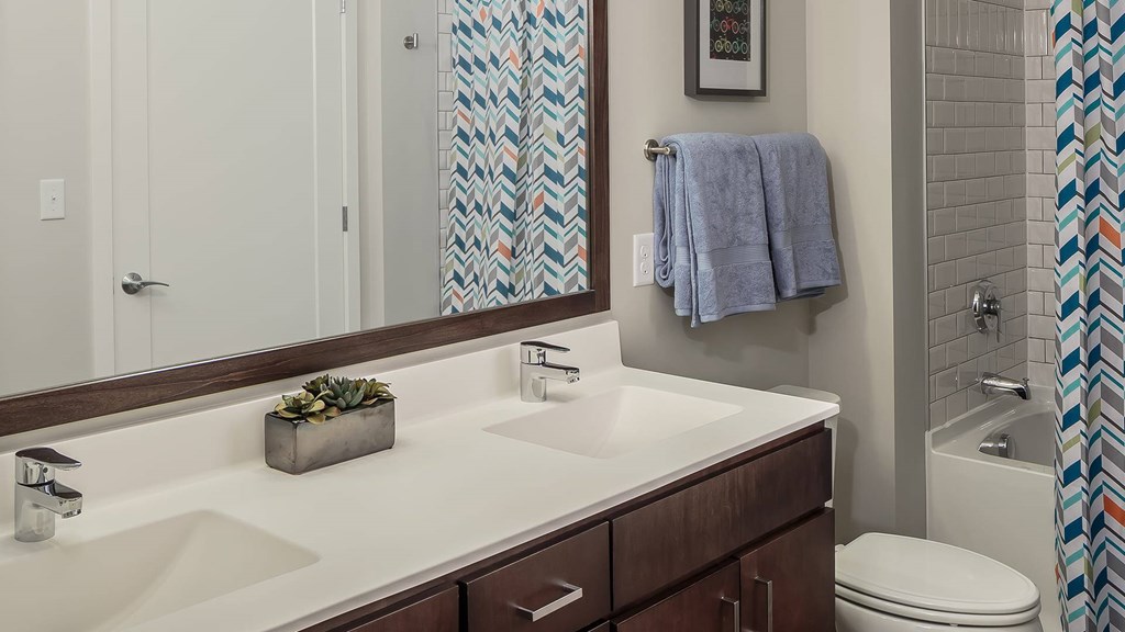 A bathroom with a white counter top and a white toilet.