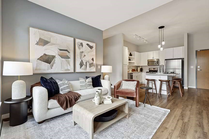 A modern living room with a white sofa, a grey coffee table, and a grey rug.