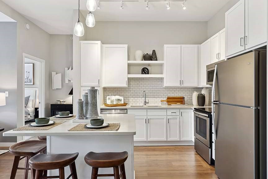 A modern kitchen with white cabinets and a wooden island.