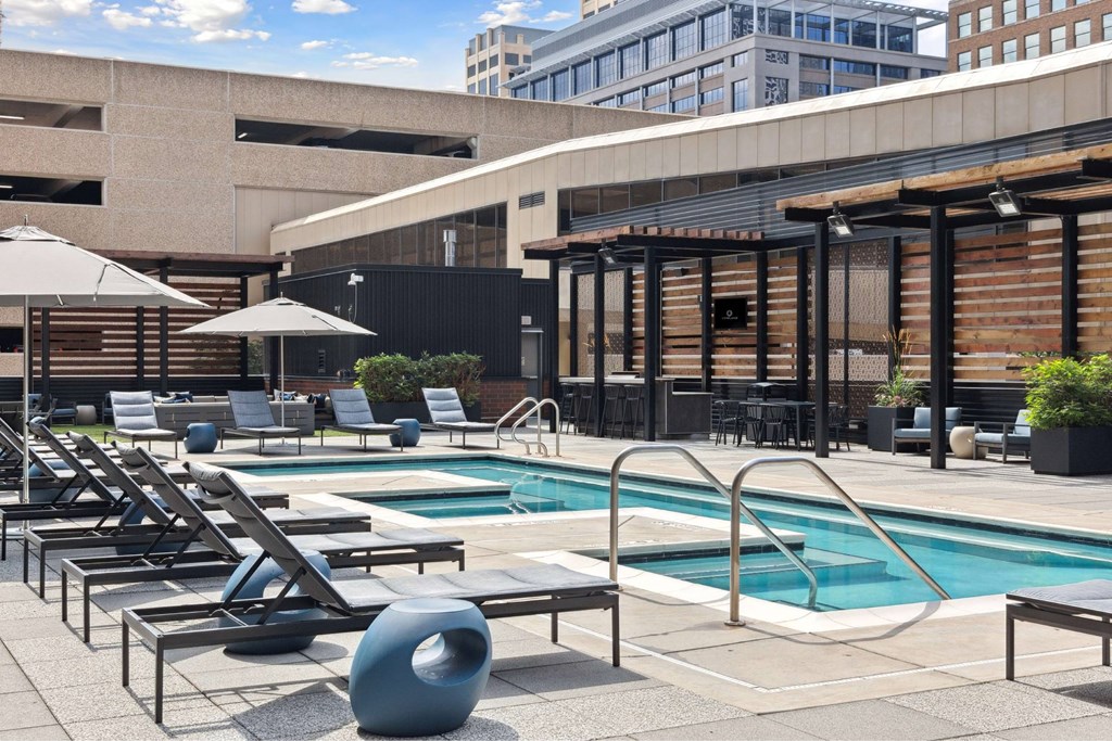 A pool area with sun loungers and a large blue ball.