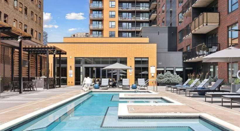 A large outdoor pool area with lounge chairs and umbrellas.
