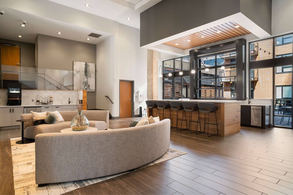 A modern living room with a curved sofa and a bar area.