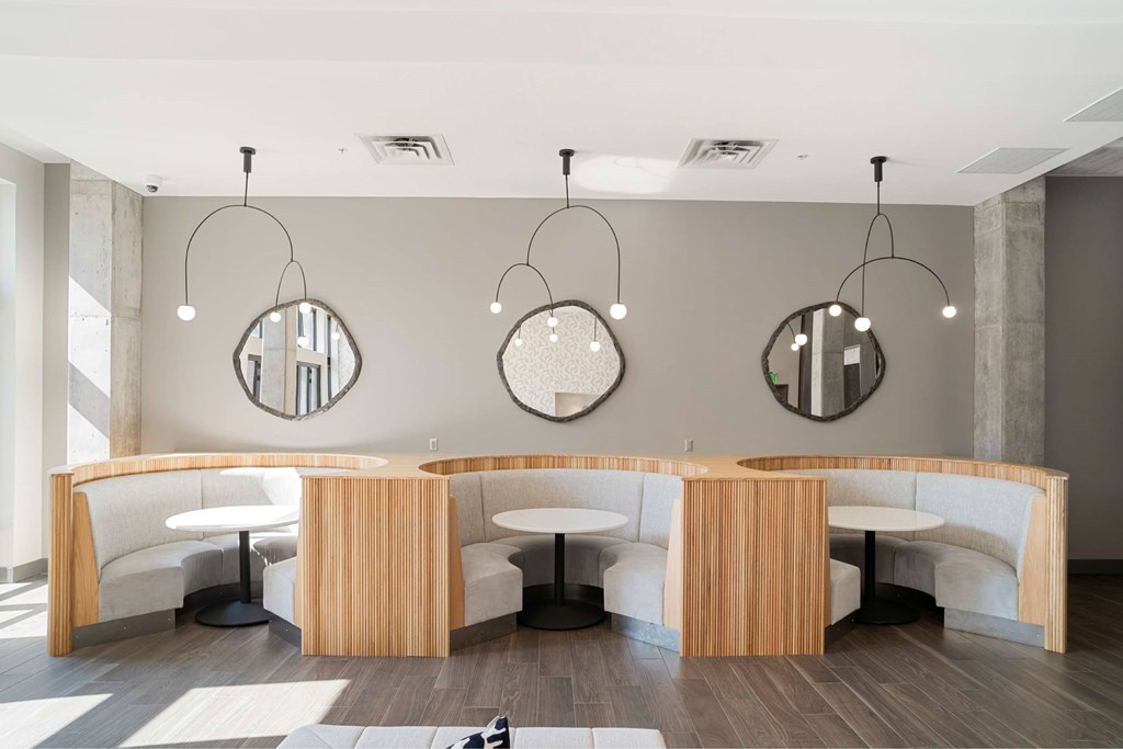 A modern meeting room with a curved wooden table and white chairs.