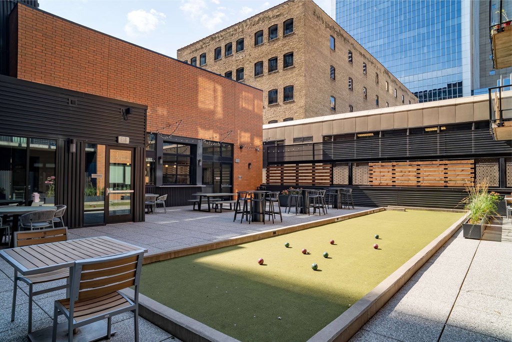 A miniature golf course is located on the patio of a building.