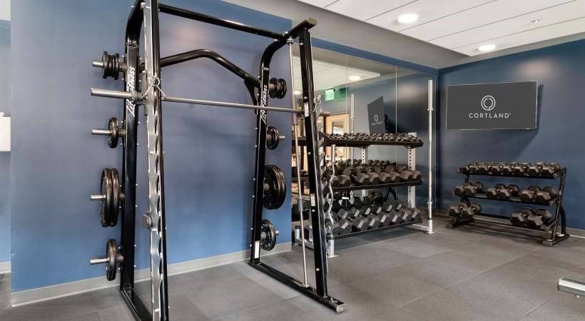 A gym with a blue wall and a sign that says "CORTLAND".