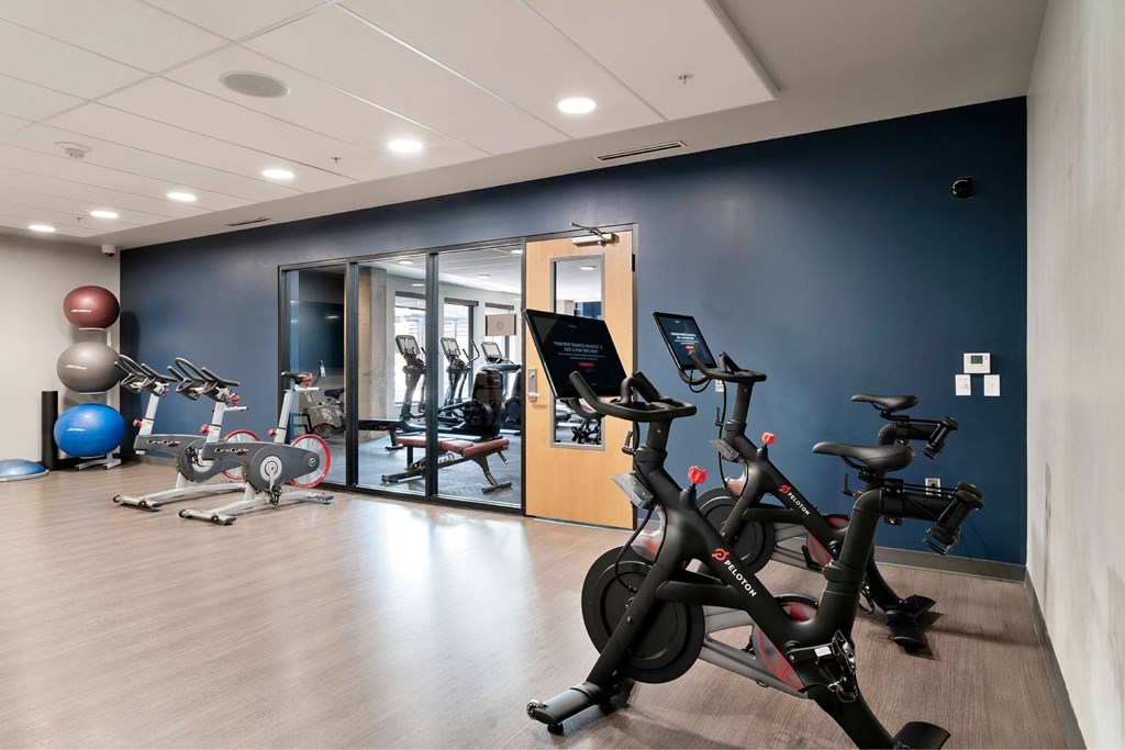 A gym with exercise equipment and a mirror.