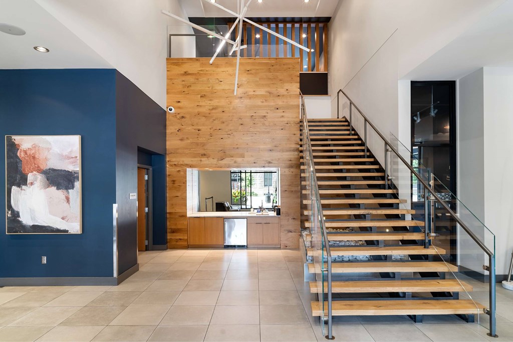 A staircase with a metal railing leads up to a wooden wall.