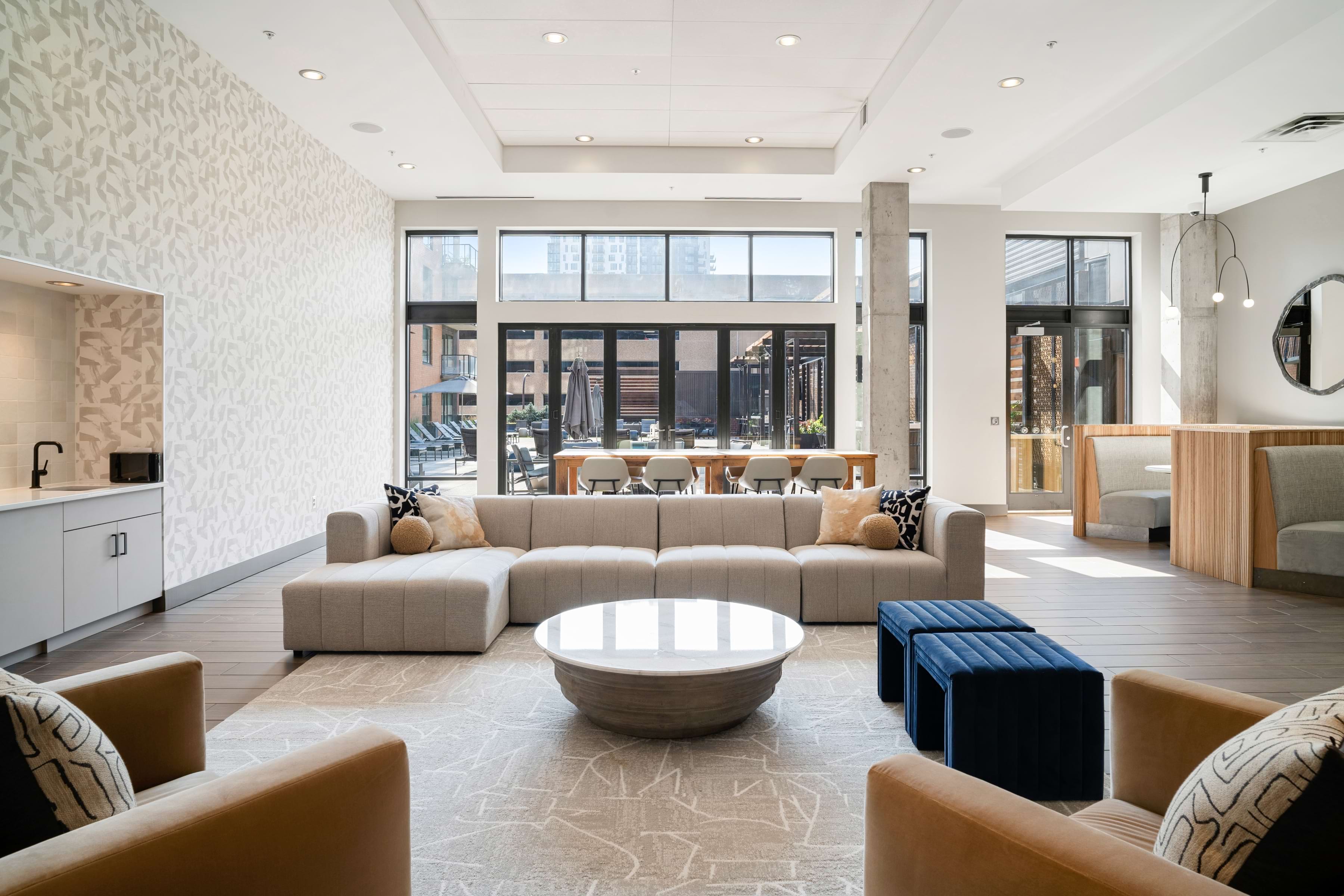 A modern living room with a large circular coffee table at the center.
