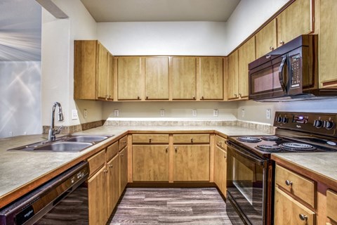 A kitchen with wooden cabinets and a microwave above the stove.