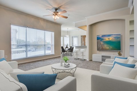 A living room with a white couch and a ceiling fan.