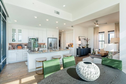 A modern living room with a grey sofa and green chairs.